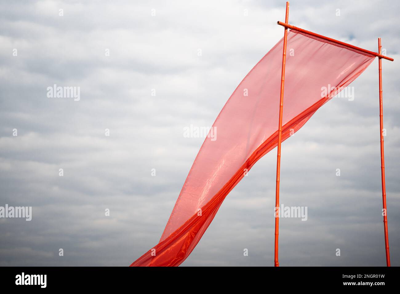Red silk cloth flying or waving in air with white clouds Stock Photo