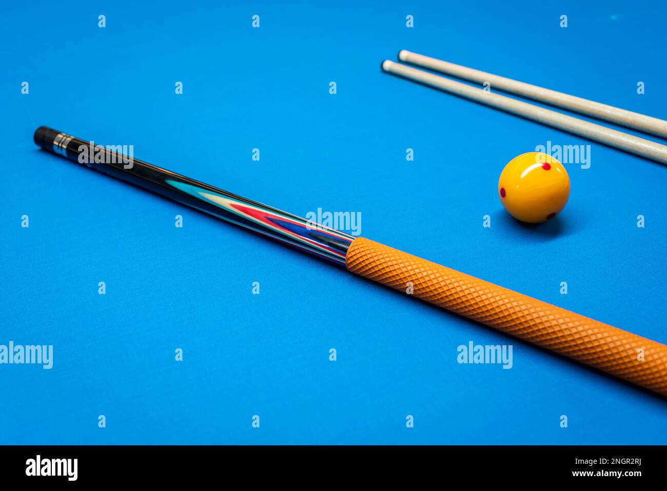 Cue sticks and a yellow ball on a billiard table Stock Photo Alamy
