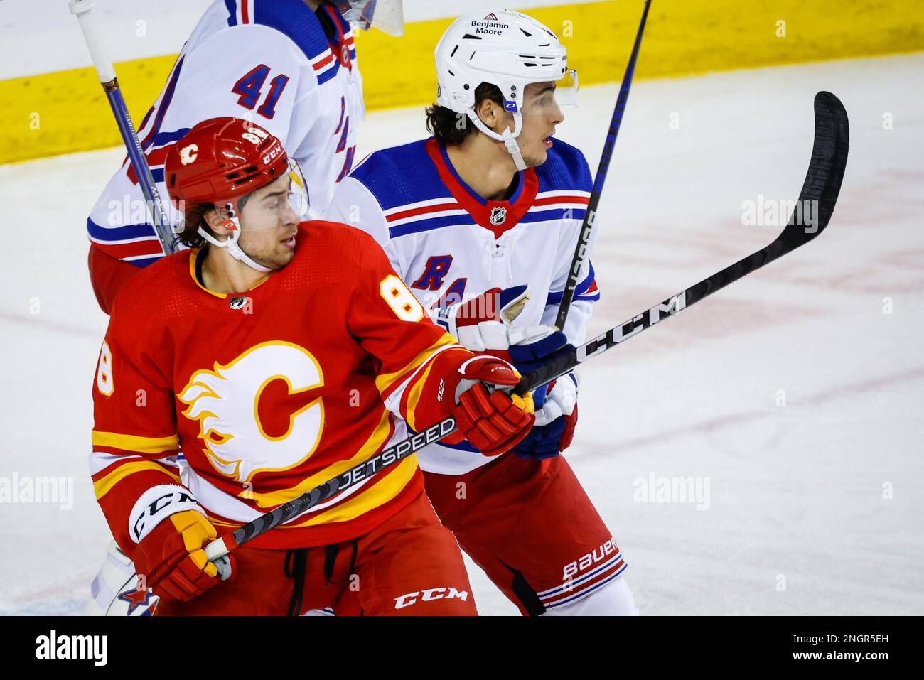 New York Rangers defenseman Braden Schneider, right, checks Calgary