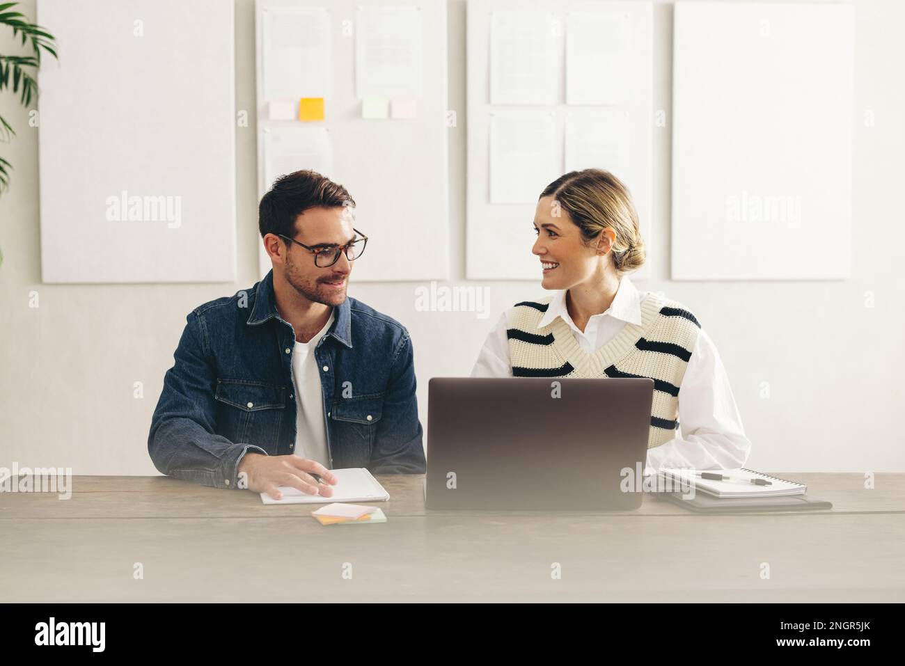 Smiling businesspeople preparing to join an online meeting on a laptop. Two happy businesspeople connecting with their global clients in a creative of Stock Photo