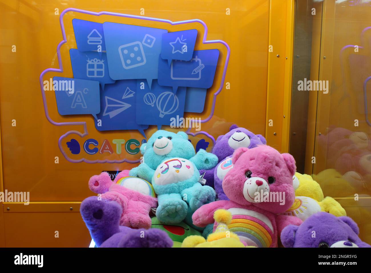 Colorful Care Bear toys in claw game machine Stock Photo
