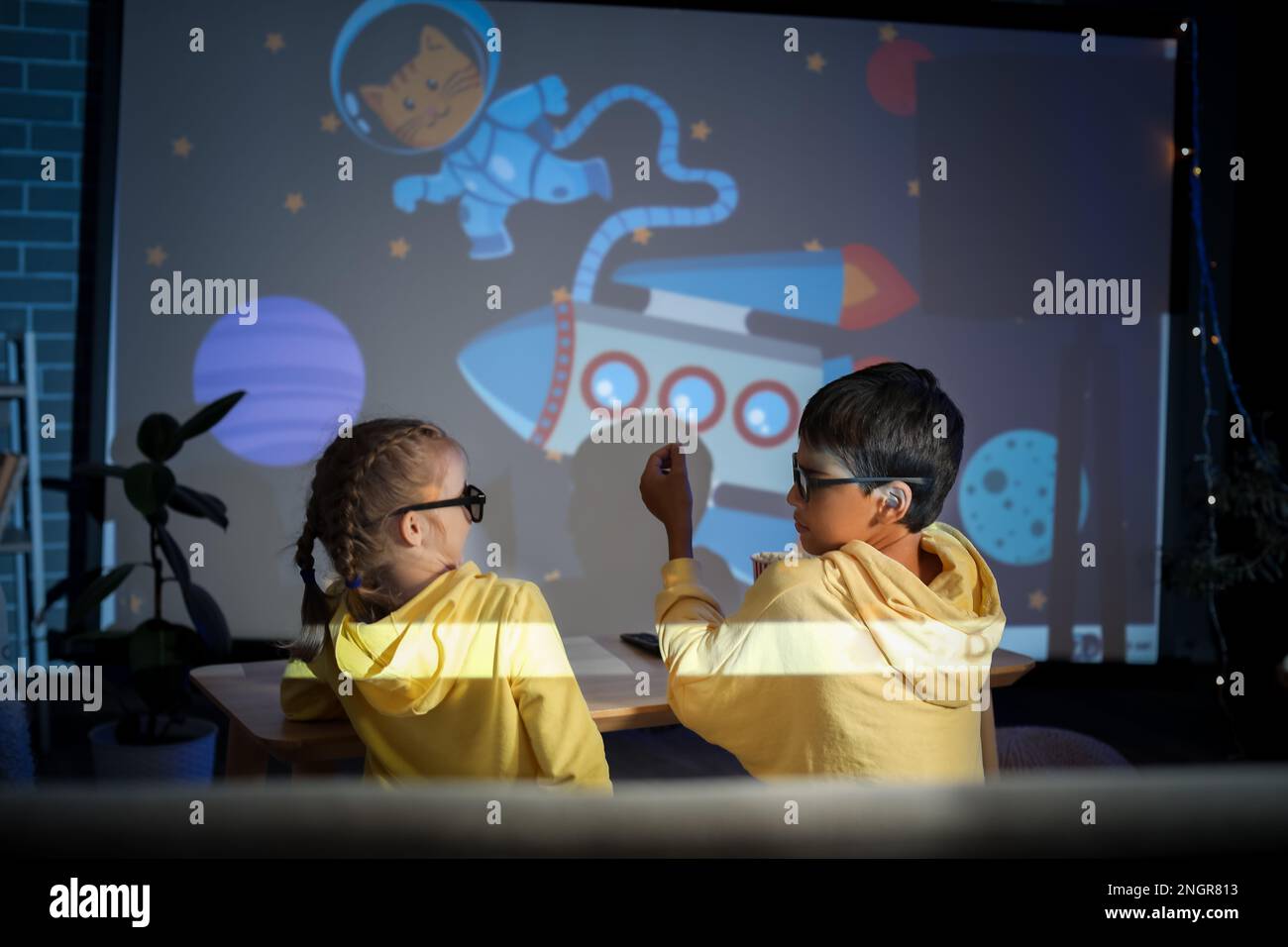 Little children in 3D glasses with popcorn watching cartoons on projector  screen at home Stock Photo - Alamy