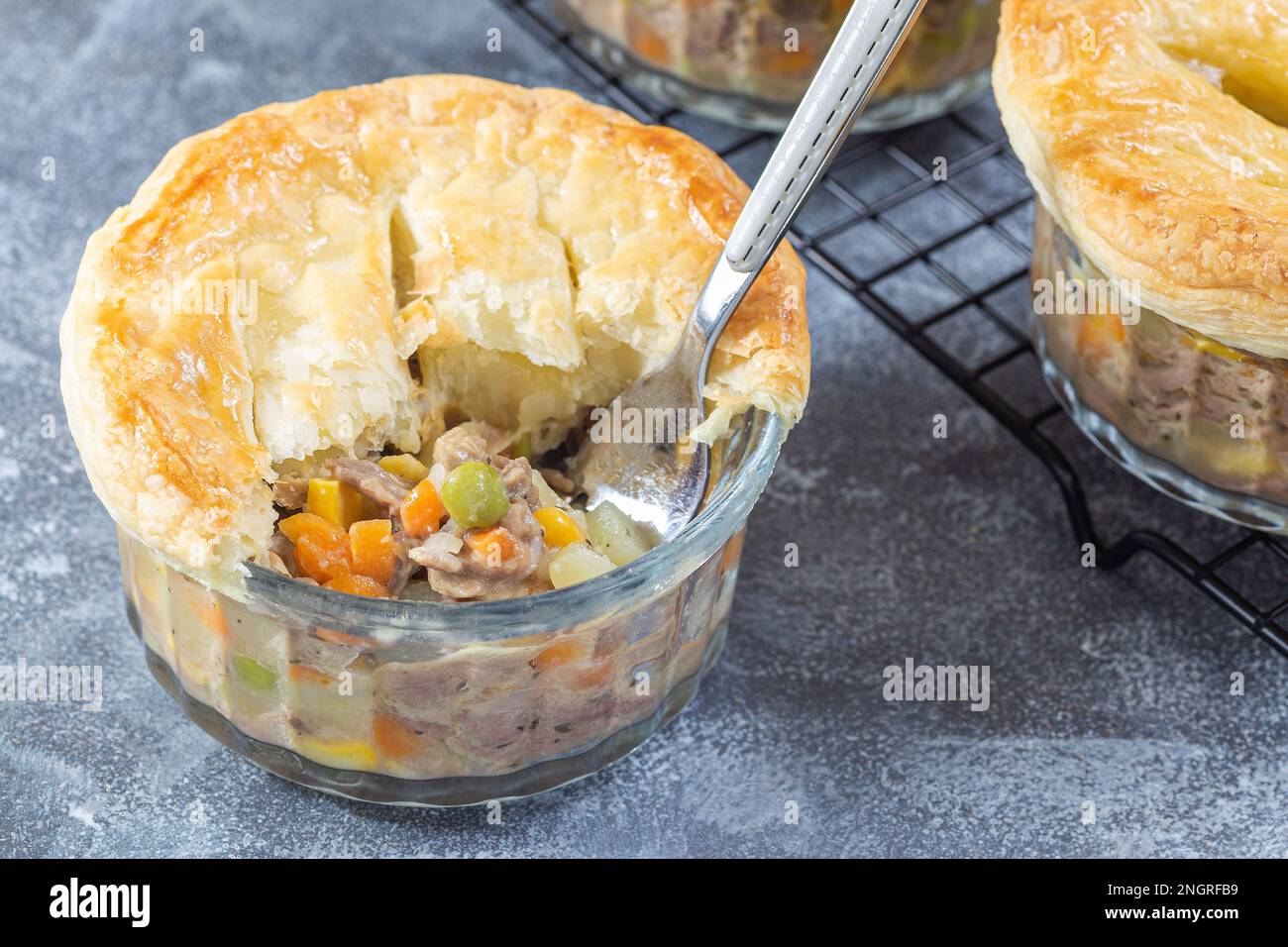 Individual beef pot pies or deep dish pies in ramekin and on cooling