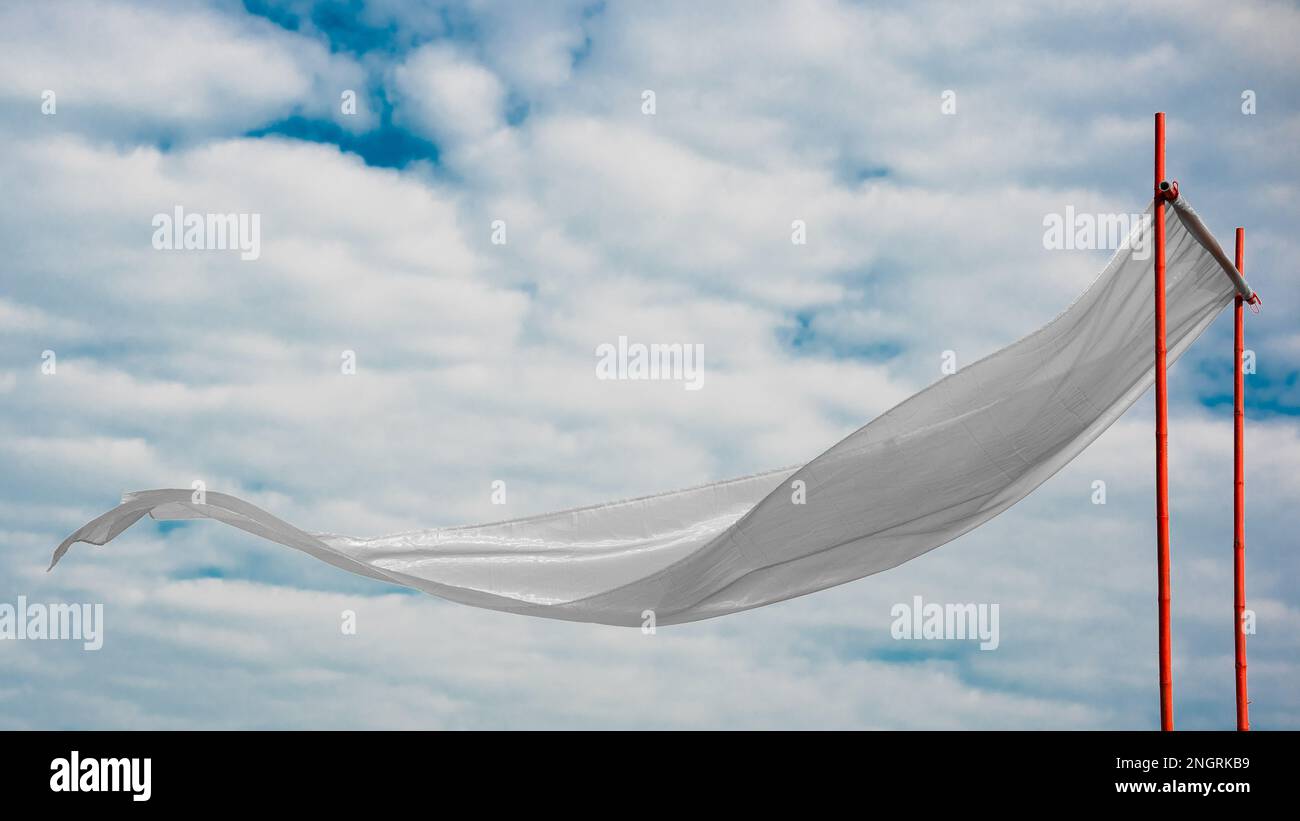 White silk cloth flying or waving in air with white clouds Stock Photo