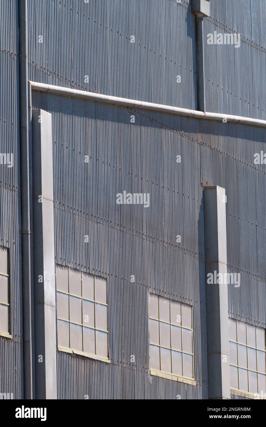Metal background texture showing a corrugated iron factory wall and windows in Castlemaine Australia. Stock Photo