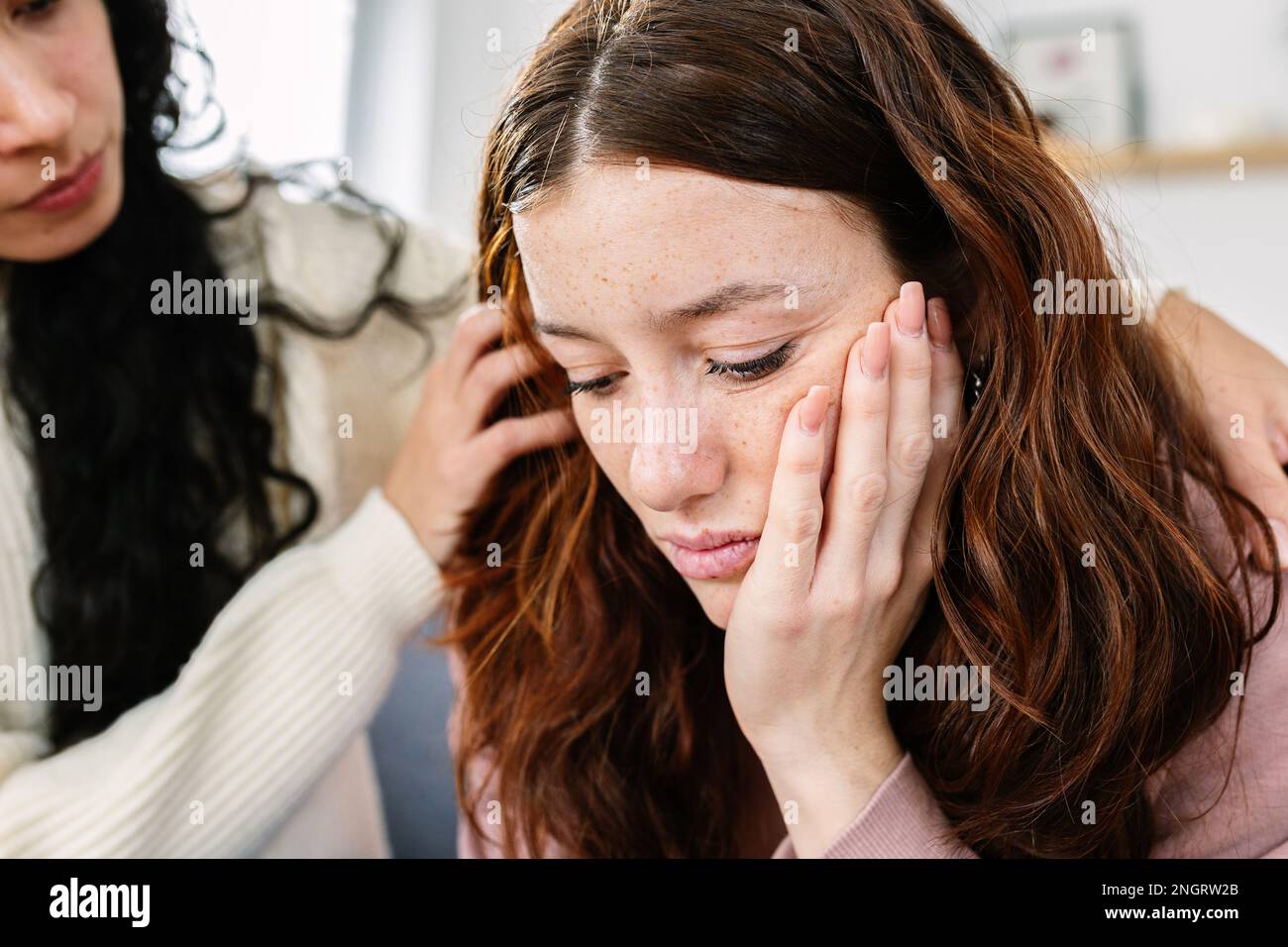 Sad young teenage girl comforted by her friend at home Stock Photo - Alamy
