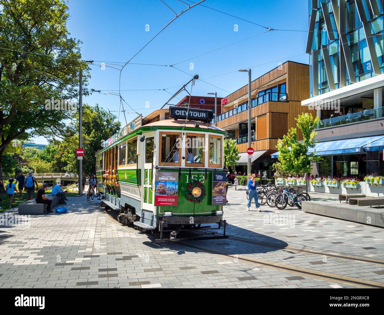 31 December 2022: Christchurch, New Zealand - A vintage tram passes The Terrace, a new riverside development. Stock Photo