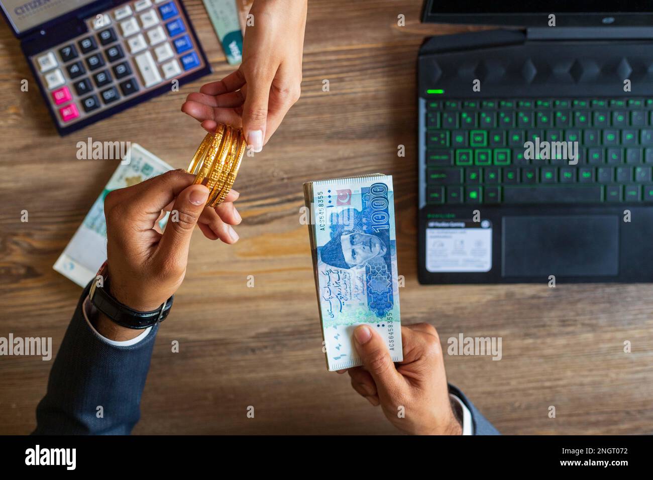 Business man hand dealing with Pakistani Ruppee Currency notes and gold for budget Saving money investment and financial accounting management or grow Stock Photo