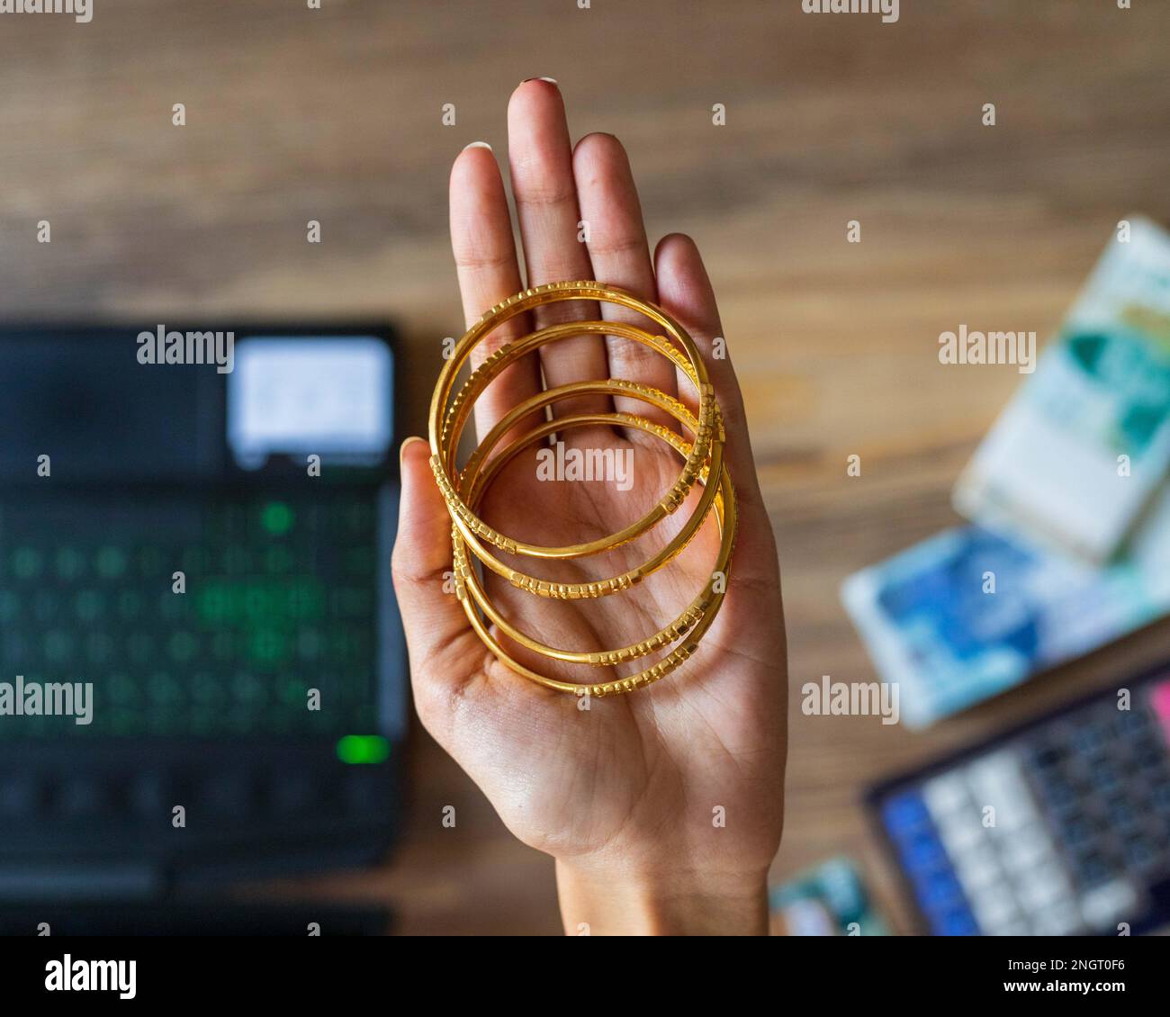 Business woman hand showing gold with Pakistani Ruppee Currency notes in background for budget Saving money investment and financial accounting manage Stock Photo
