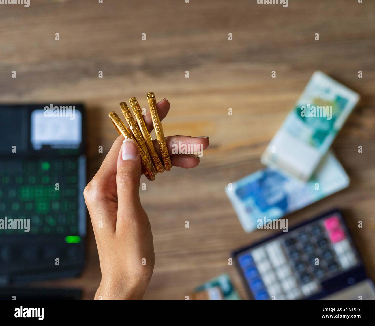 Business woman hand showing gold with Pakistani Ruppee Currency notes in background for budget Saving money investment and financial accounting manage Stock Photo