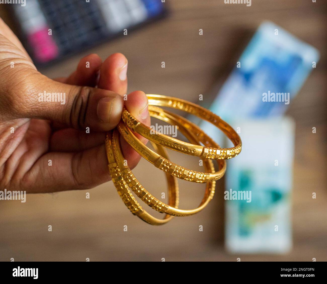 Business man hand showing gold with Pakistani Ruppee Currency notes in background for budget Saving money investment and financial accounting manageme Stock Photo