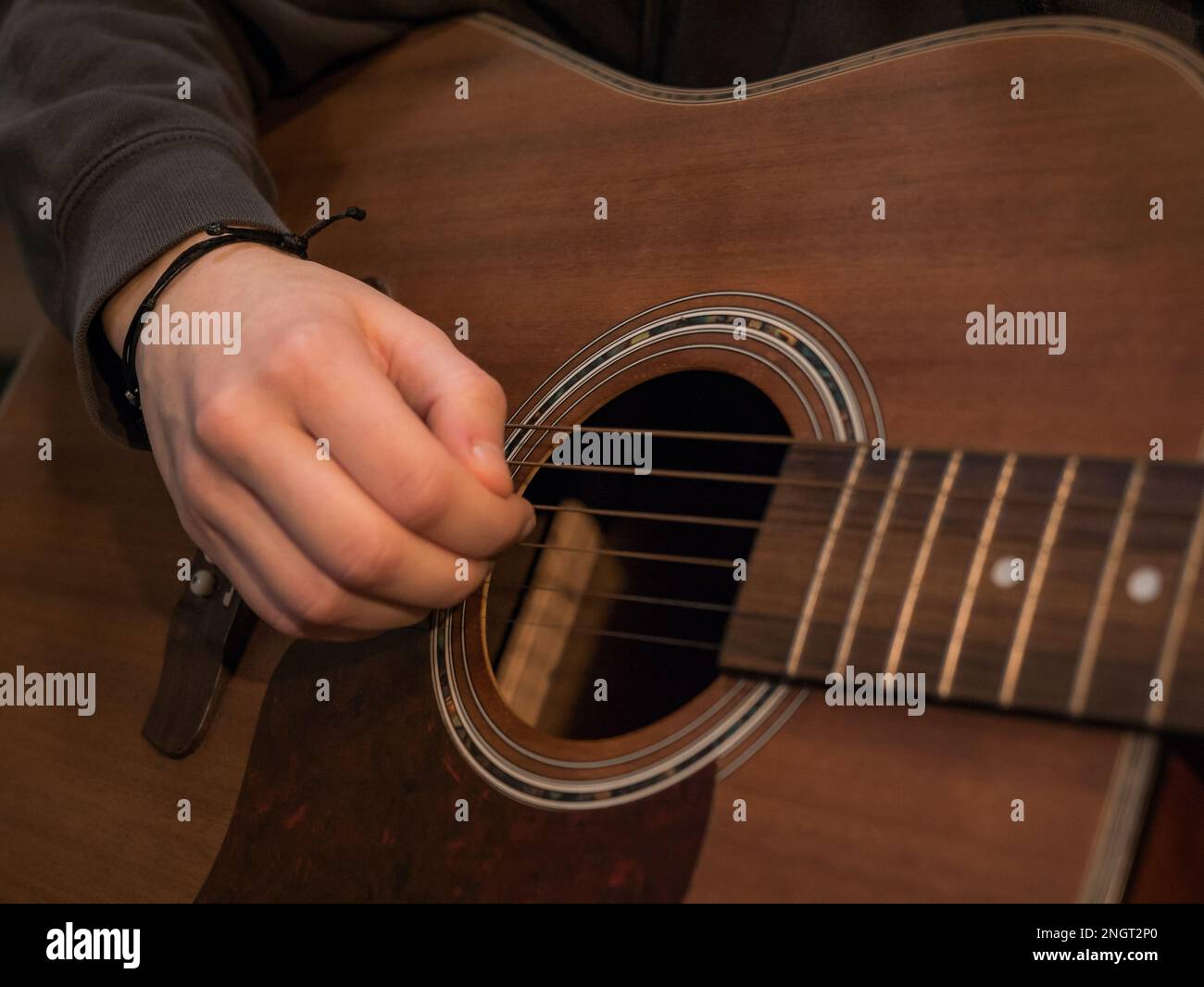 Practice playing the acoustic guitar. Hands playing guitar and picking