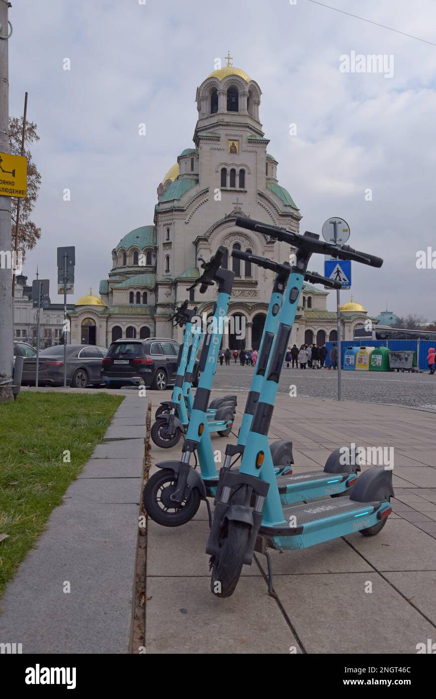 A row of BinBin electric dockless hire scooters outside the St. Alexander Nevsky Cathedral, Sofia, Bulgaria Stock Photo