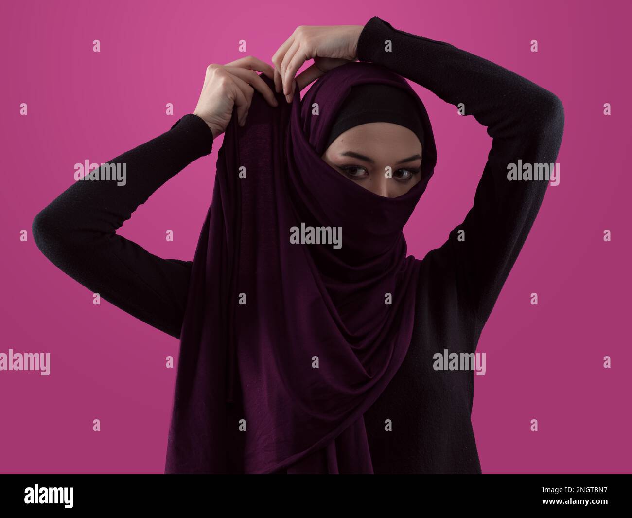 Modern Muslim woman wearing stylish hijab casual wear isolated on pink ...
