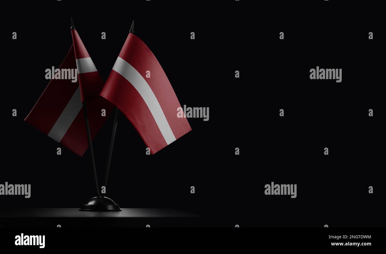 Small national flags of the Latvia on a black background. Stock Photo