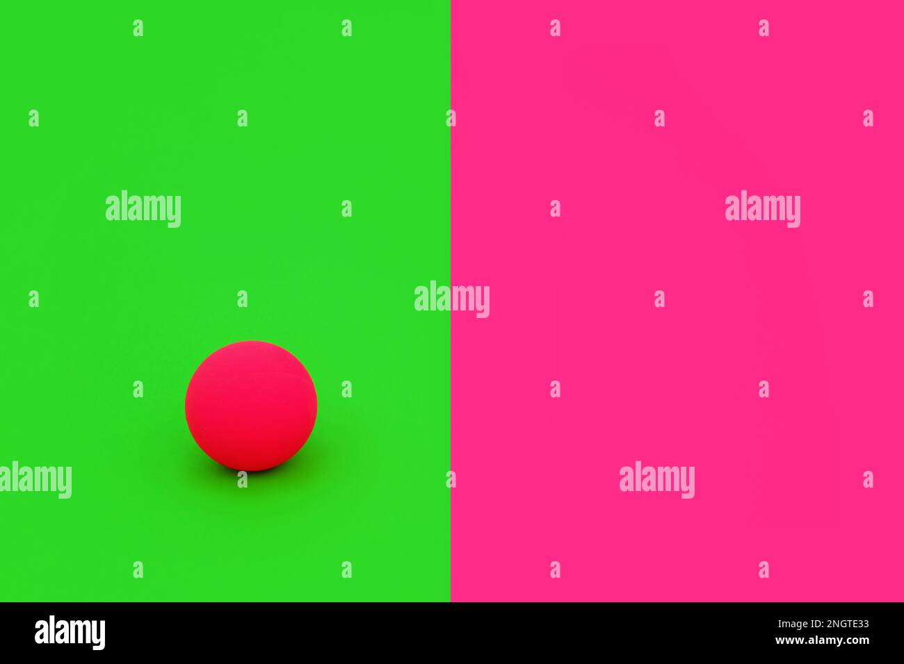 Dare to be different and independent concept with vivid green and pink contrast background with ball. Minimal solitary, alone, leadership, concept. Stock Photo