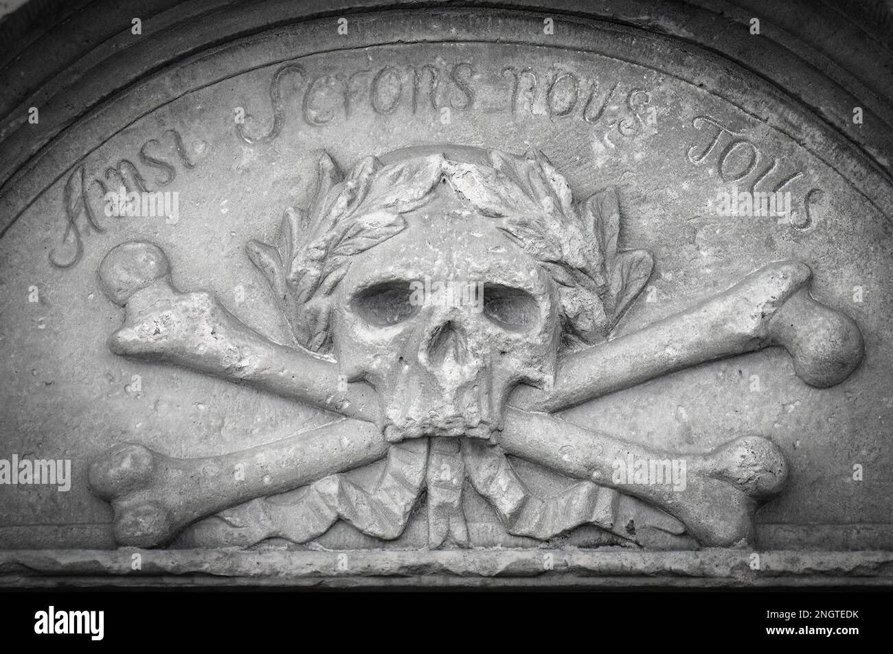 A stone carving of a skull and crossbones Stock Photo