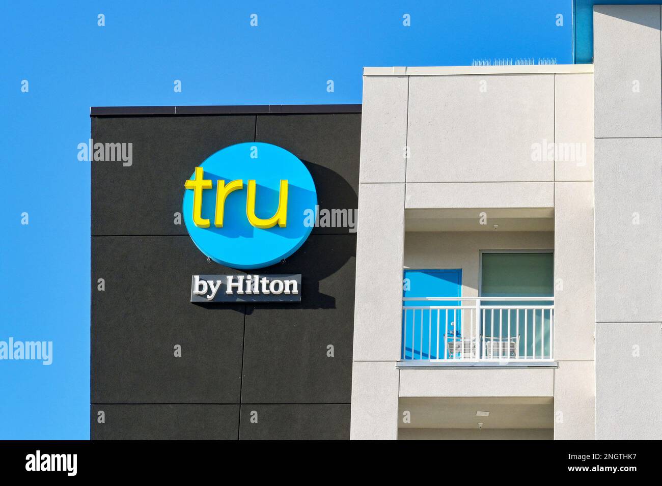 Galveston, Texas - February 2023: Sign on the outside of the Tru hotel, which is part of the Hilton chain of hotels Stock Photo