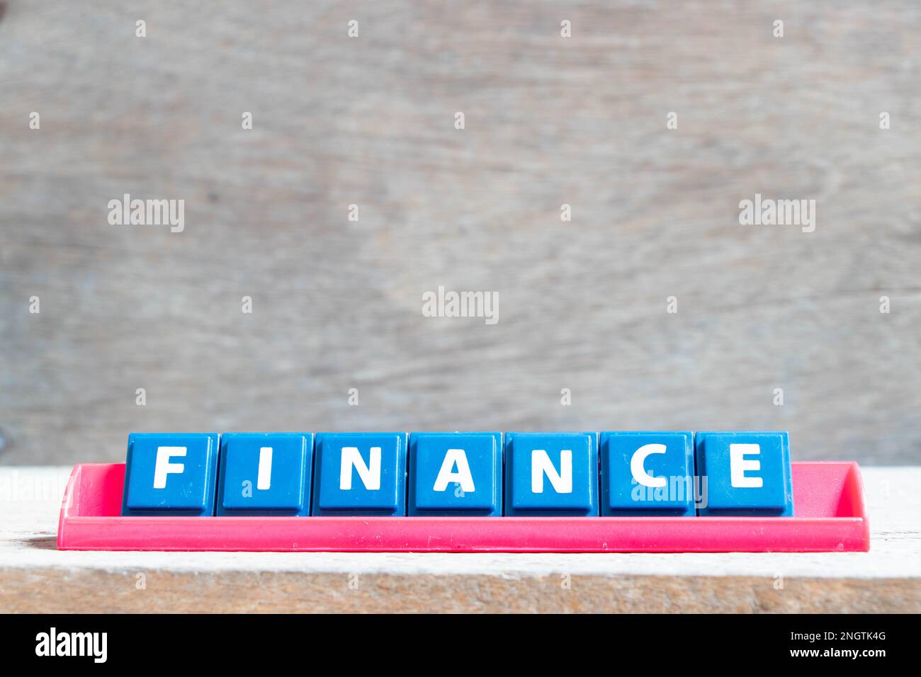 Tile alphabet letter with word finance in red color rack on wood ...