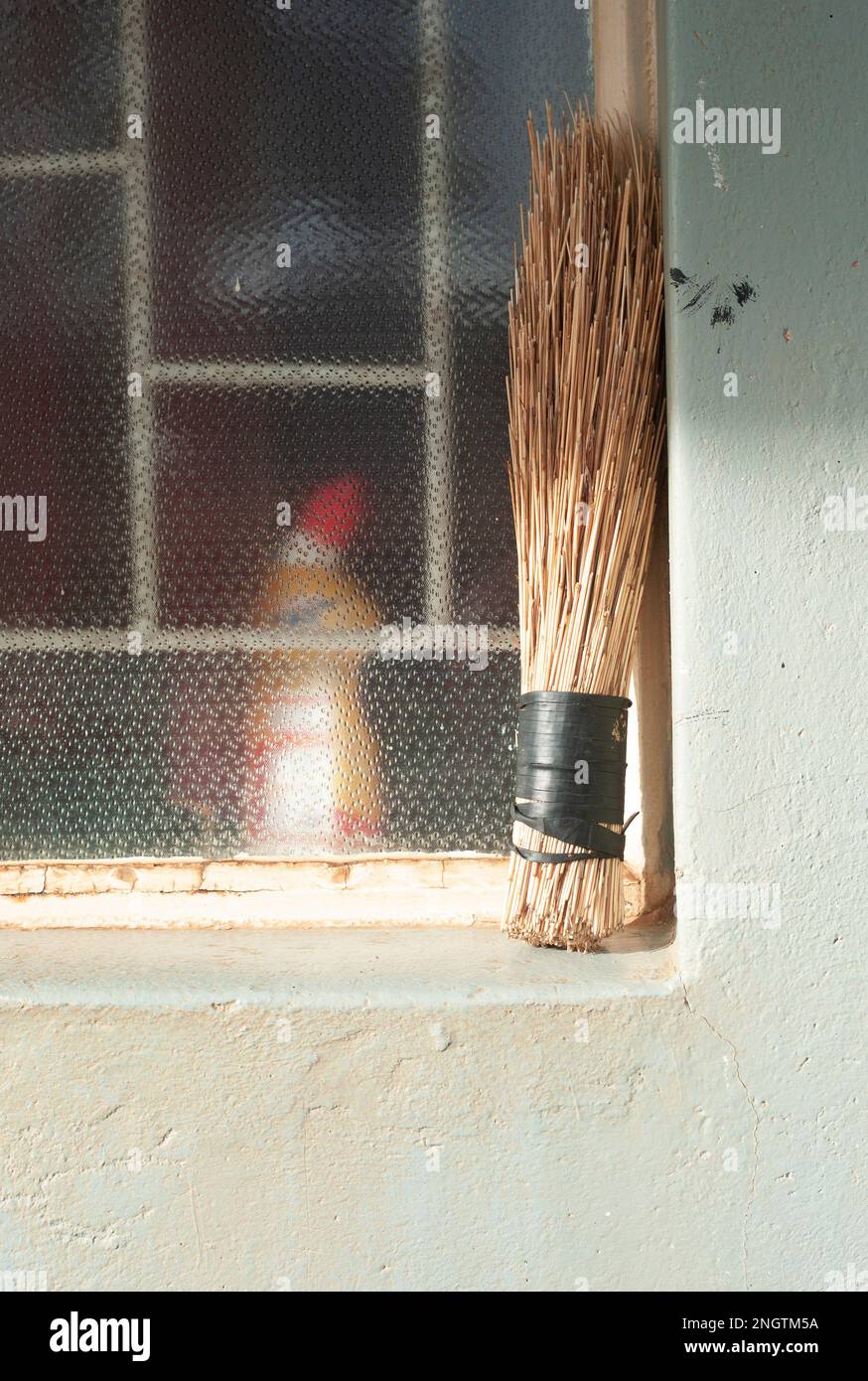 Straw broom balanced on the window ledge of a Zambian home Stock Photo