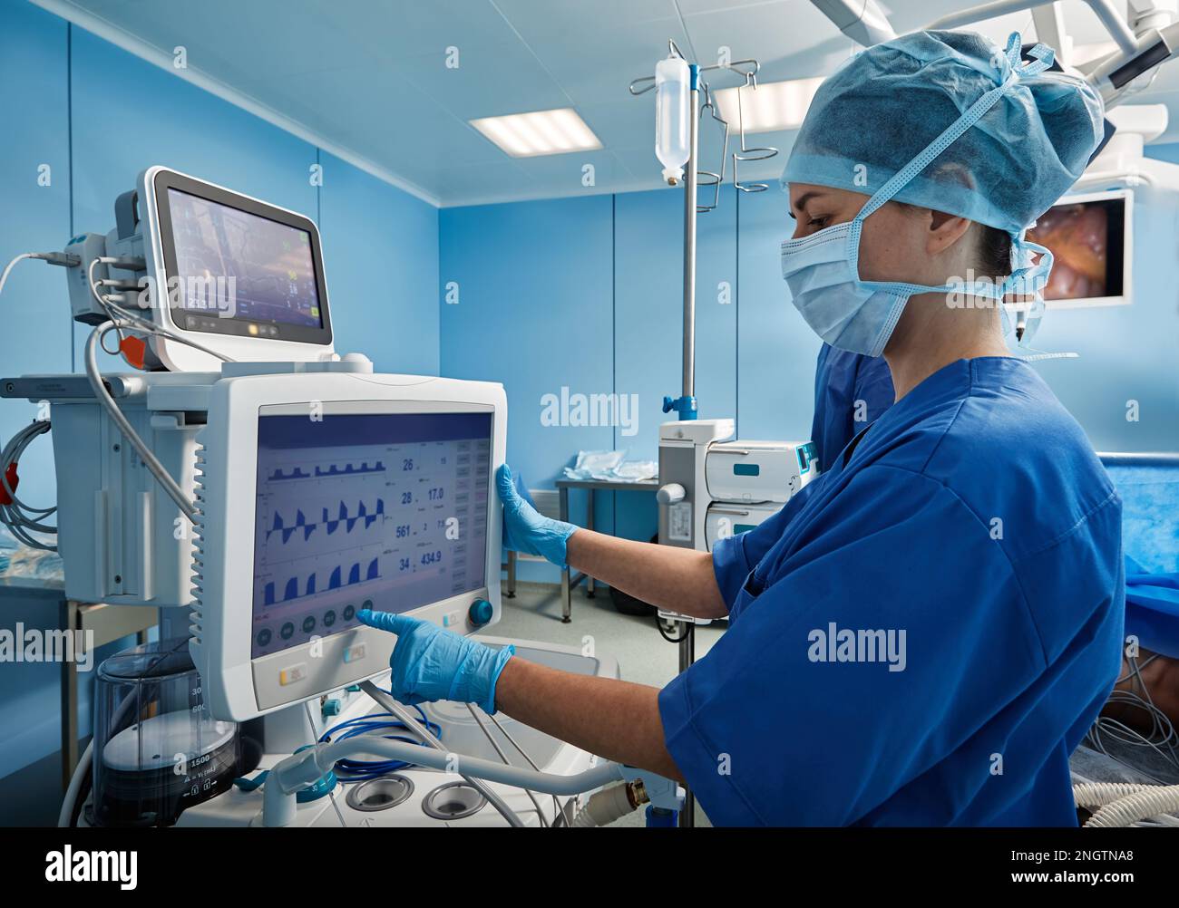 Nurse in operating room of hospital checking patient's vital signs while surgical operation. Surgical department Stock Photo