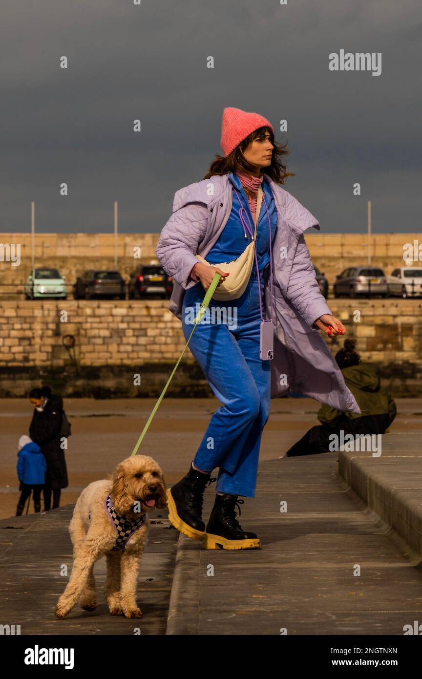 Margate, UK. 18 Feb 2023. Walking the dog on the harbour wall and beach