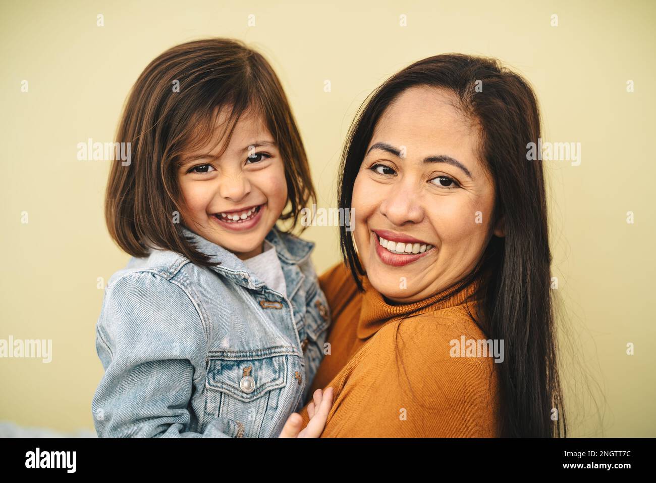 Happy filipina mother with her daughter smiling in front of camera - Lovely family portrait Stock Photo