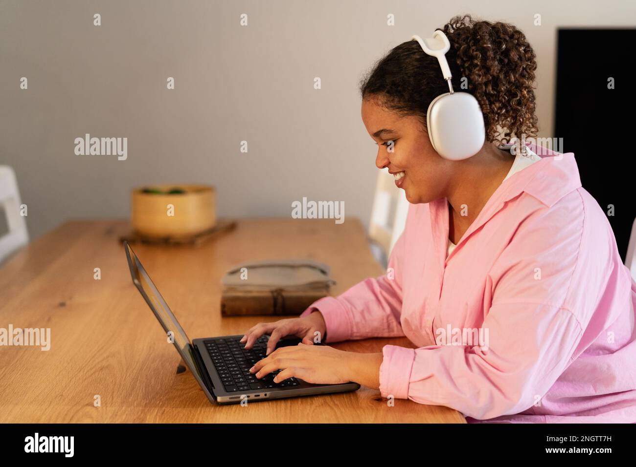 Young African girl using laptop listening podcast with headphones at home Stock Photo