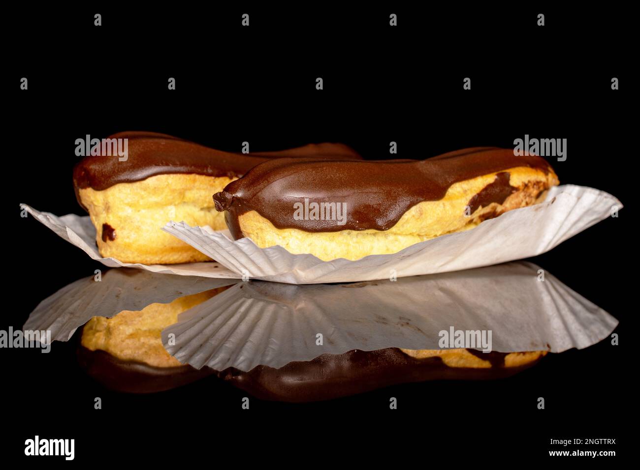 Two chocolate eclairs, macro, isolated on black background. Stock Photo