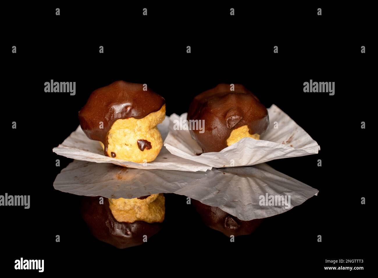Two chocolate eclairs, macro, isolated on black background. Stock Photo