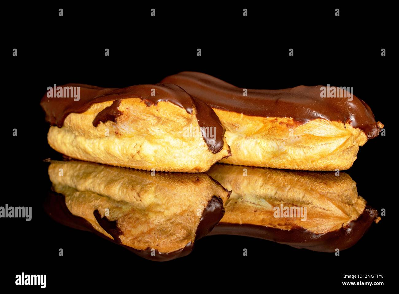 Two chocolate eclairs, macro, isolated on black background. Stock Photo