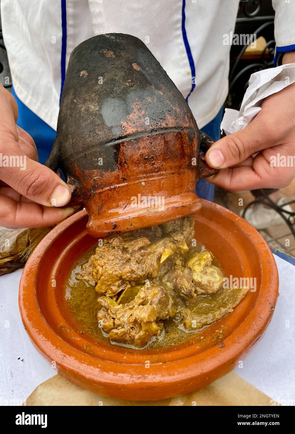 Man Pouring Tangia Tanjia A Local Dish From Marrakech Roasted Lamb Cooked In Clay Pots Into