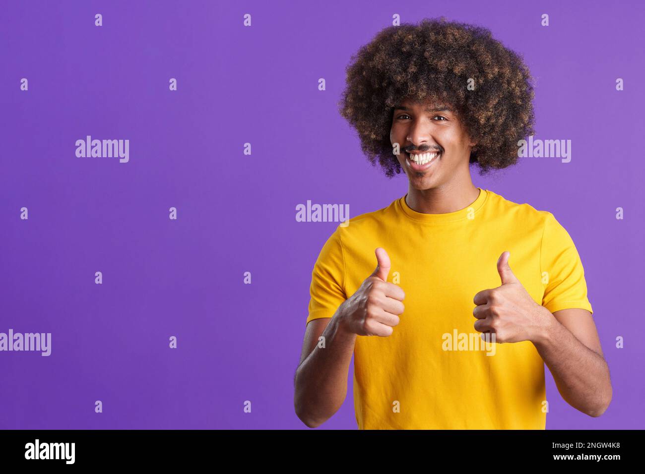 African man with curly hair gesturing agreement raising thumbs up Stock Photo