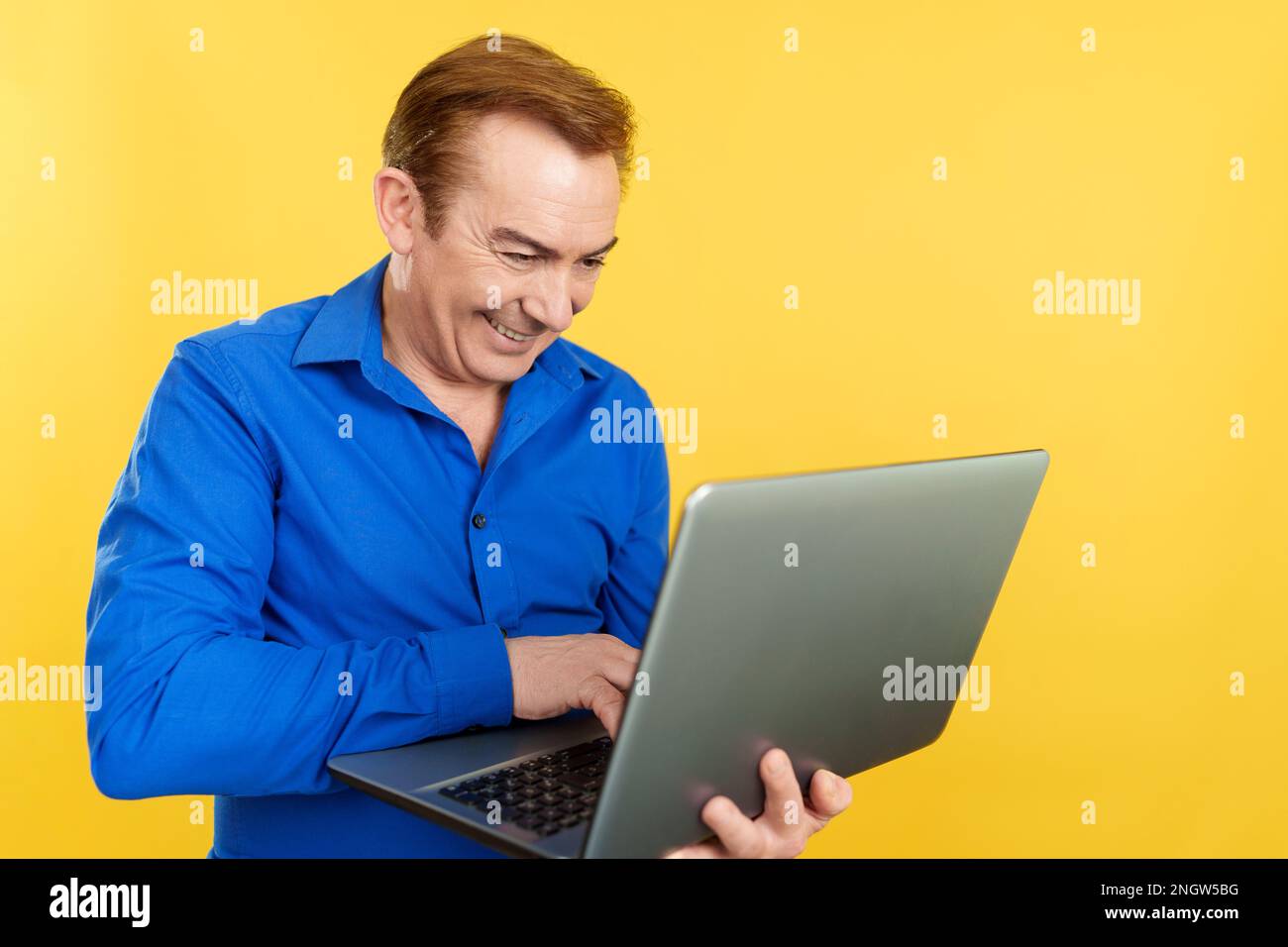 Happy mature man talking laptop hi-res stock photography and images - Alamy