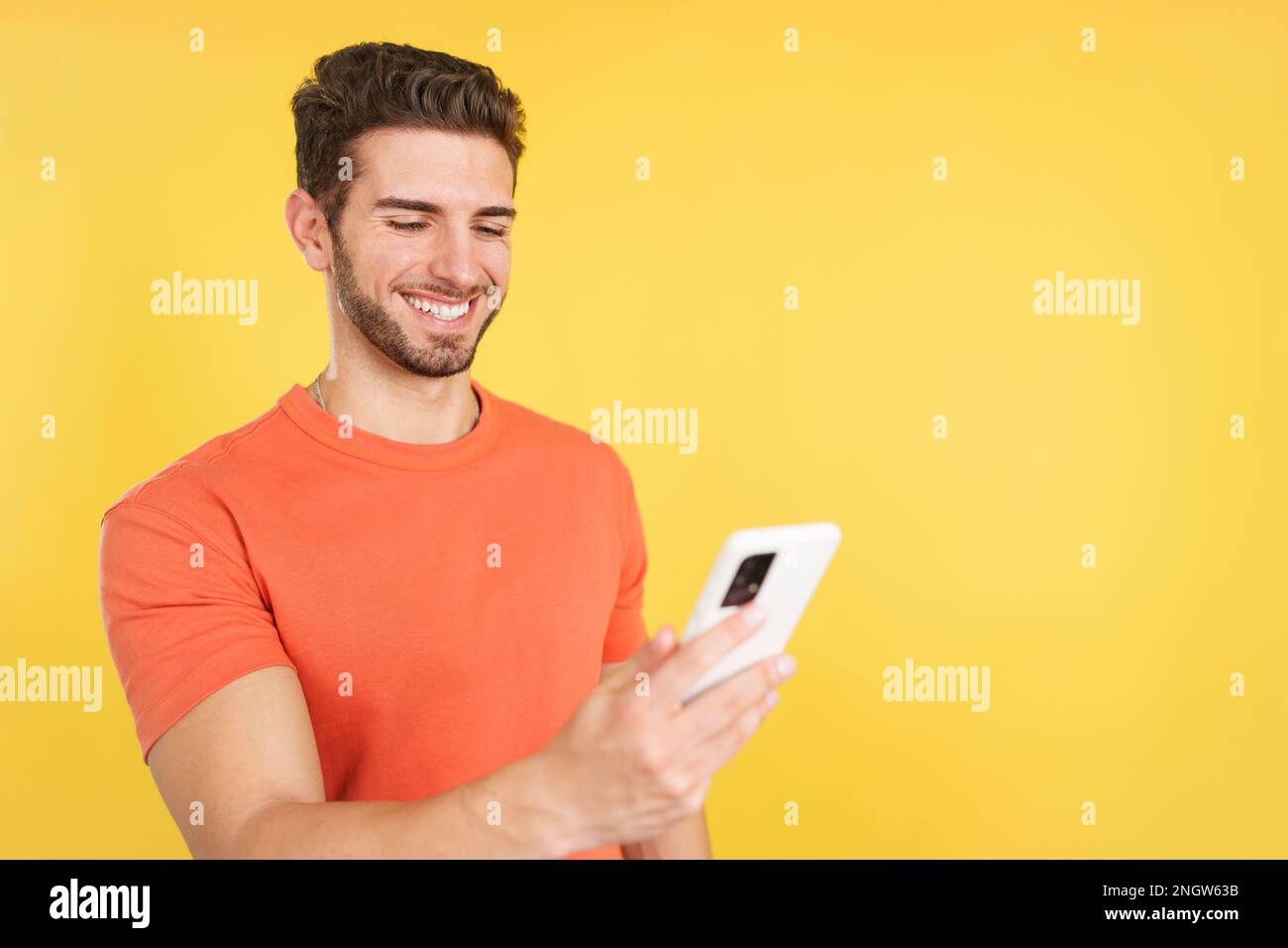 Happy caucasian man smiling while using the mobile Stock Photo