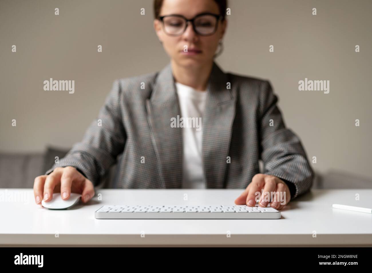Businesswoman working on pc with blank virtual monitor using wireless keyboard and computer mouse, space for photomontage insert infographic. Stock Photo