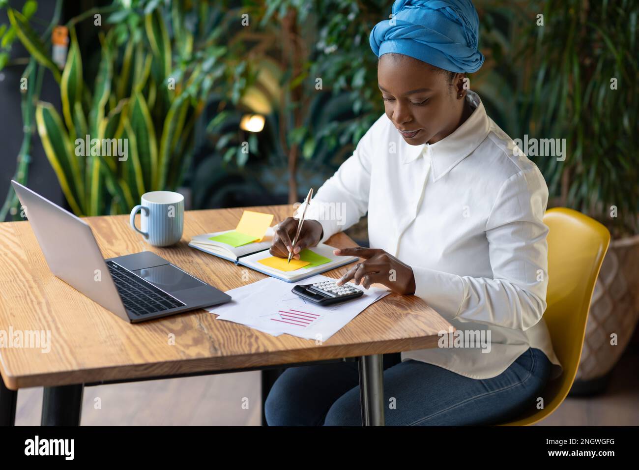 Black woman working at cafe, using laptop, copy space Stock Photo