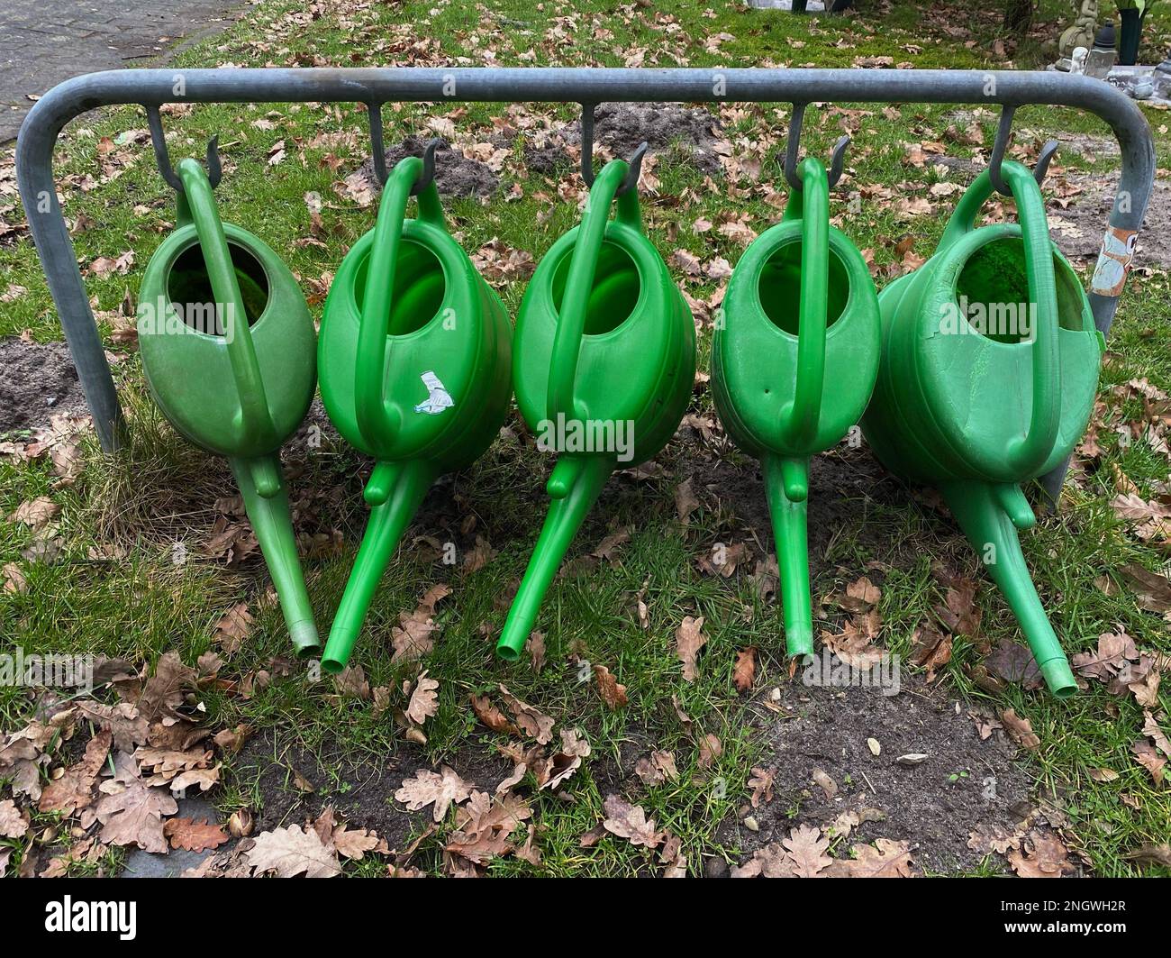 Empty watering cans offered free of charge at a cemetery for watering graves or flowers. Stock Photo
