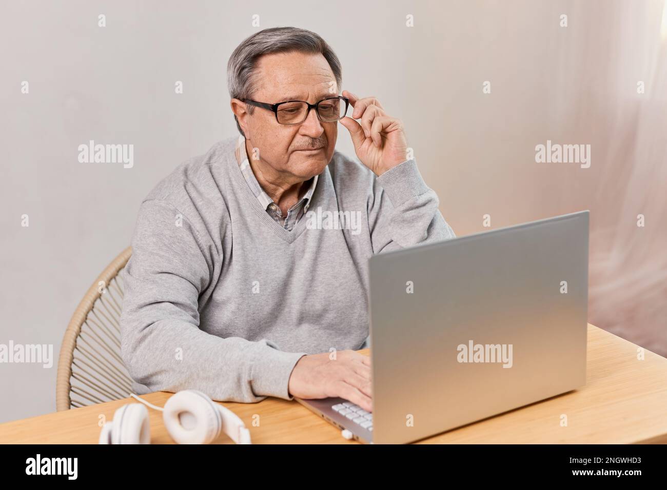 Senior man at home connected on laptop computer Stock Photo