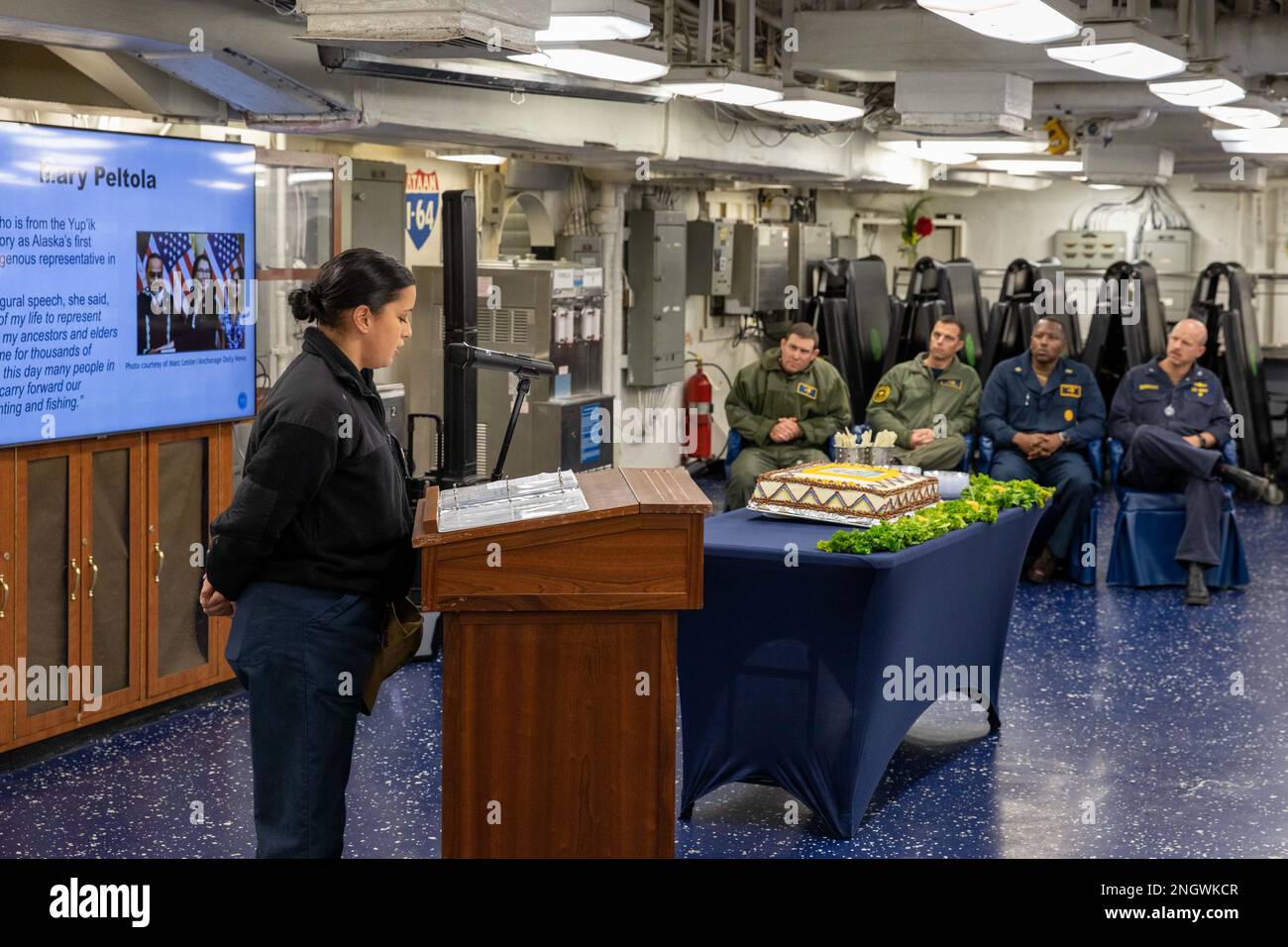 221129-N-OM737-1050  NORFOLK, Va. (Nov. 29, 2022) Boatswain’s Mate 3rd Class Kristin Rucker, assigned to the Wasp-class amphibious assault ship USS Bataan (LHD 5), gives a presentation during the ship’s National American-Indian Heritage Month celebration on the ship’s mess decks, Nov. 29, 2022. The Bataan also celebrated the event with an invocation and a ceremonial cake cutting. Stock Photo
