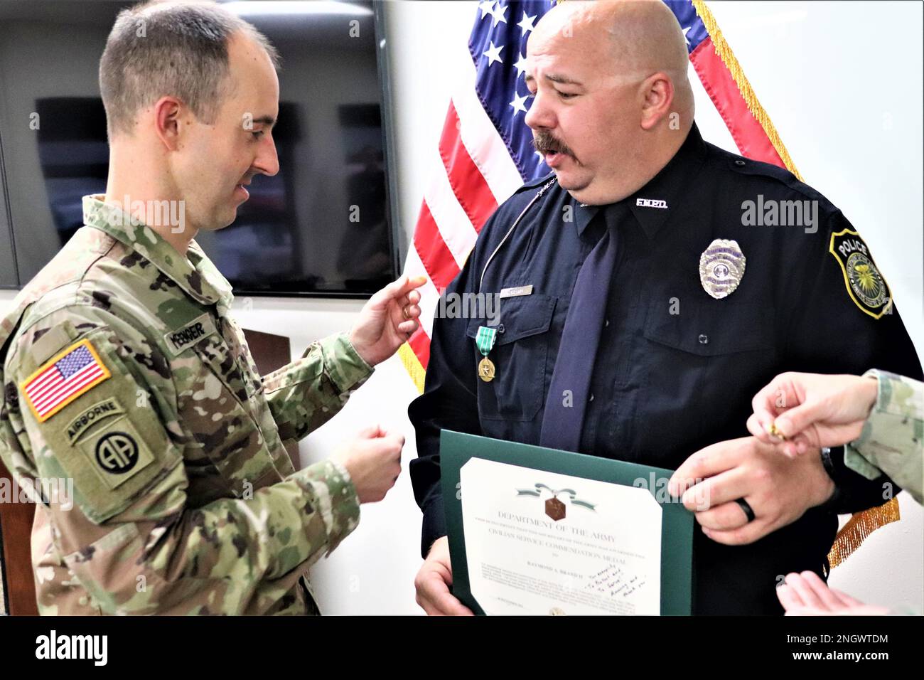 Police Officer Raymond A. Brand II receives the Department of the Army Civilian Service Commendation Medal for “exceptional service and performance” Nov. 29, 2022, at Fort McCoy, Wis., from Fort McCoy Garrison Commander Col. Stephen Messenger due to “heroic” efforts to rescue two people in a vehicle accident in February 2022 in Sparta, Wis. The ceremony was held at the Fort McCoy Directorate of Emergency Services headquarters with both firefighters and police officers in attendance as well as Brand’s wife Jennifer, and Command Sgt. Maj. Raquel DiDomenico, Fort McCoy Garrison command sergeant m Stock Photo