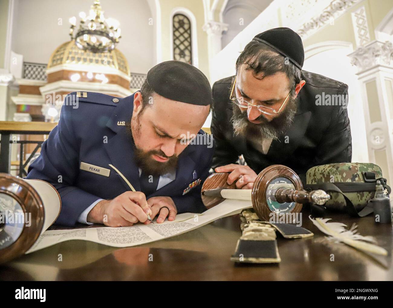 WARSAW, Poland - U.S. Air Force Capt. Levy Pekar, left, from Beitar, Israel, Chaplain of the 86th Airlift Wing based out of Ramstein Air Base, Germany, signs a Torah Scroll dedicated to the Ukrainian Army as Hillel Cohen, Military Rabbinate of Ukraine, watches during the ceremony, Nov. 29, 2022, Warsaw, Poland. Jewish Chaplains alongside distinguished guests, refugees from Ukraine, and U.S. ally partner nations attended the event to support the Ukrainian Chaplaincy’s religious support efforts. Stock Photo