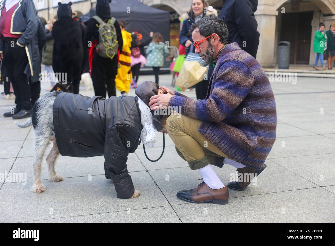 Aviles, Spain, 19th February, 2023: A man puts glasses on his dog during the Antroxaes Pet Contest on February 18, 2023, in Aviles, Spain. Credit: Alberto Brevers / Alamy Live News Stock Photo