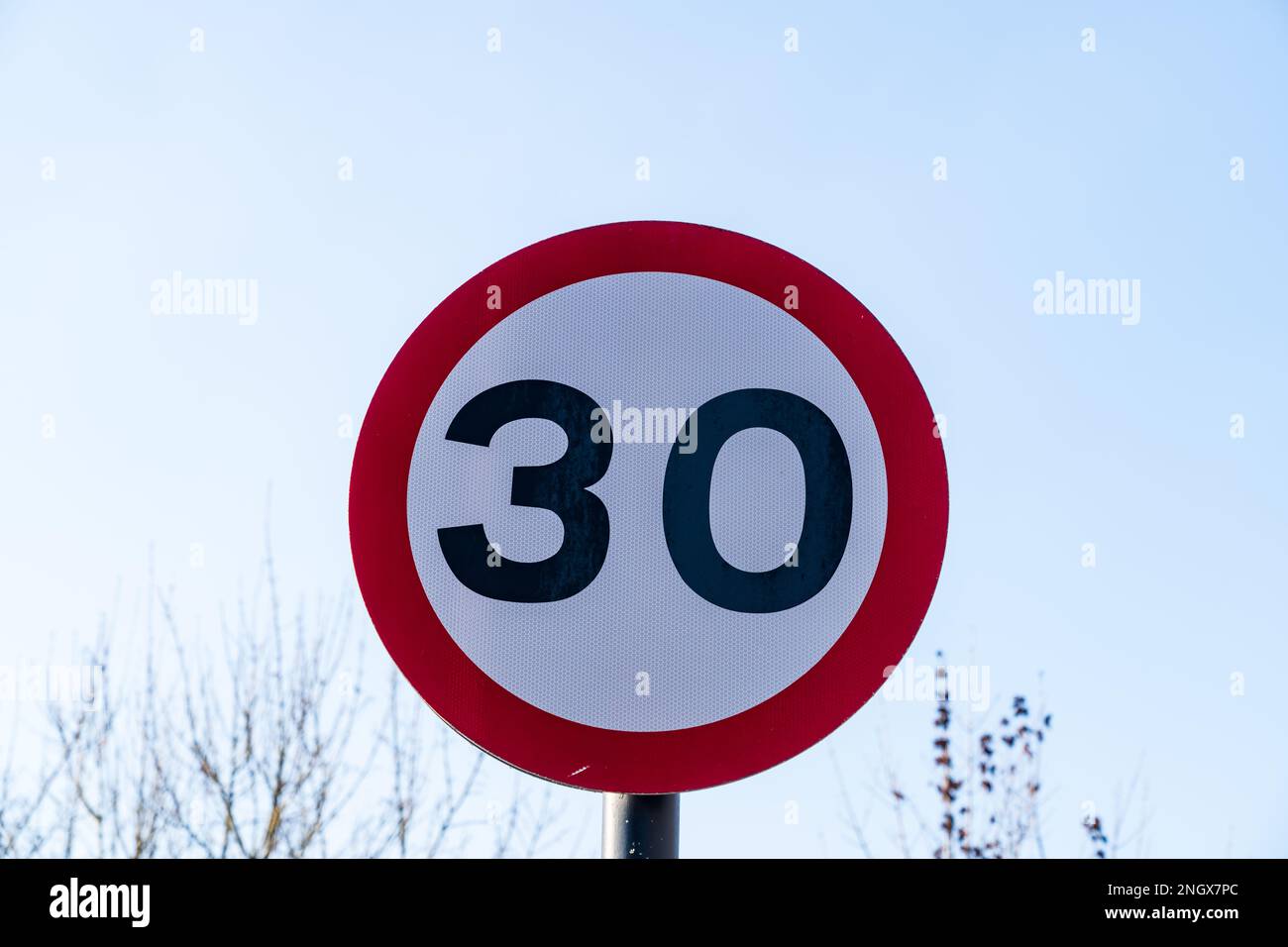 UK Traffic sign showing.a 30 mph maximum speed limit with a red and white warning circle Stock Photo