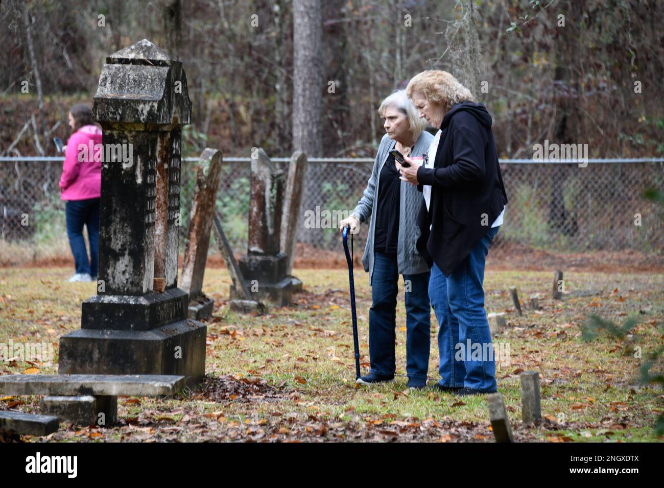 Cousins Patricia Warmack and Gayle Parrish read the headstone of one of their family members in the Little Creek Cemetery, Nov. 30 on Fort Stewart. Over 40 community members visited Fort Stewart, Nov. 29 for the annual tour featured eight cemeteries, each belonging to communities that once resided on the 288,000 acres of land that is now the training area belonging to the 3rd Infantry Division. Stock Photo