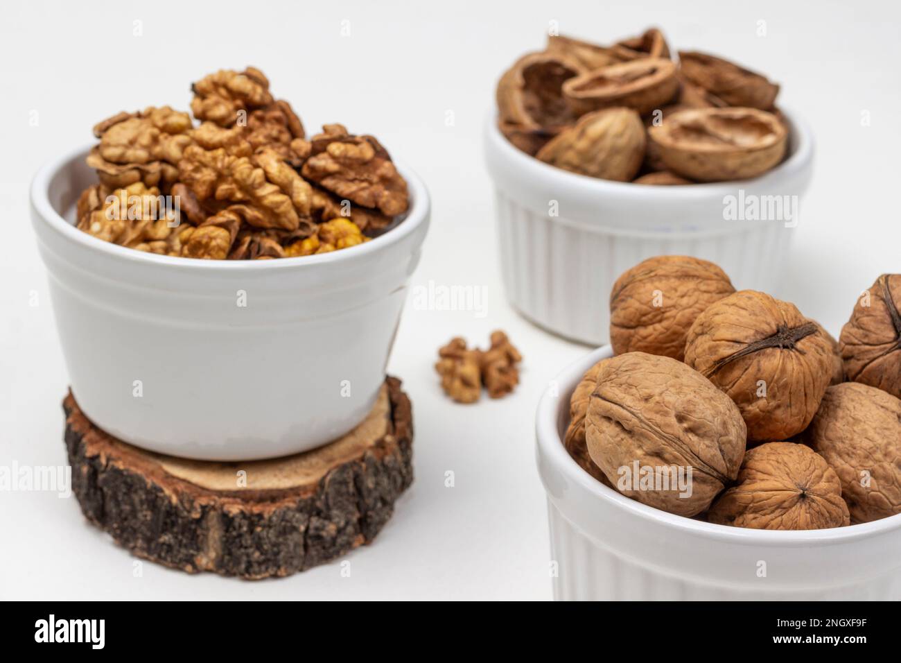 Nuts, shells and nut kernels in white bowls. Close up. Top view. White