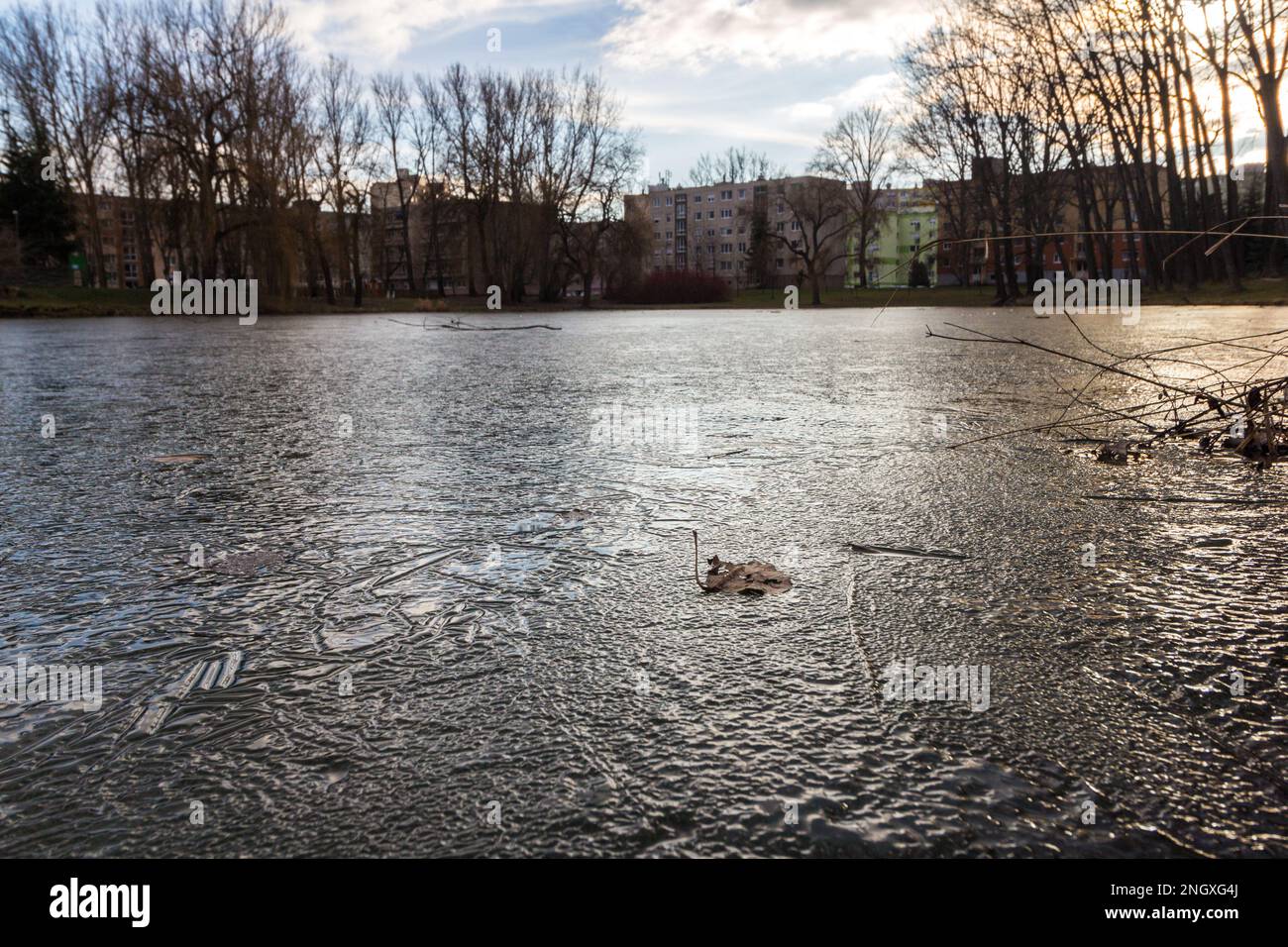 Artificial fishing lake frozen in winter with residential district Jerevan in background, Ibolya-to, Sopron, Hungary Stock Photo