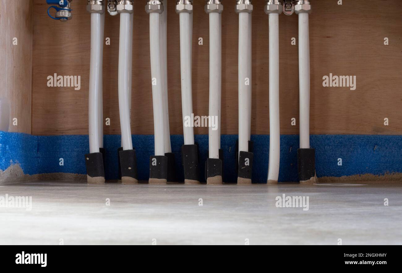 Underfloor heating pipes connecting to heating manifold Stock Photo Alamy