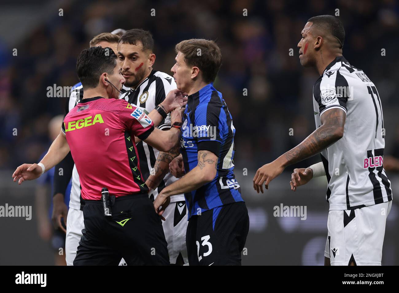 Milan, Italy, 18th February 2023. The Referee Federico Dionisi breaks up Roberto Pereyra of Udinese Calcio and Nicolo Barella of FC Internazionale after the Udinese midfielder reacted to the FC international midfielder's penalty appeals during the Serie A match at Giuseppe Meazza, Milan. Picture credit should read: Jonathan Moscrop / Sportimage Stock Photo