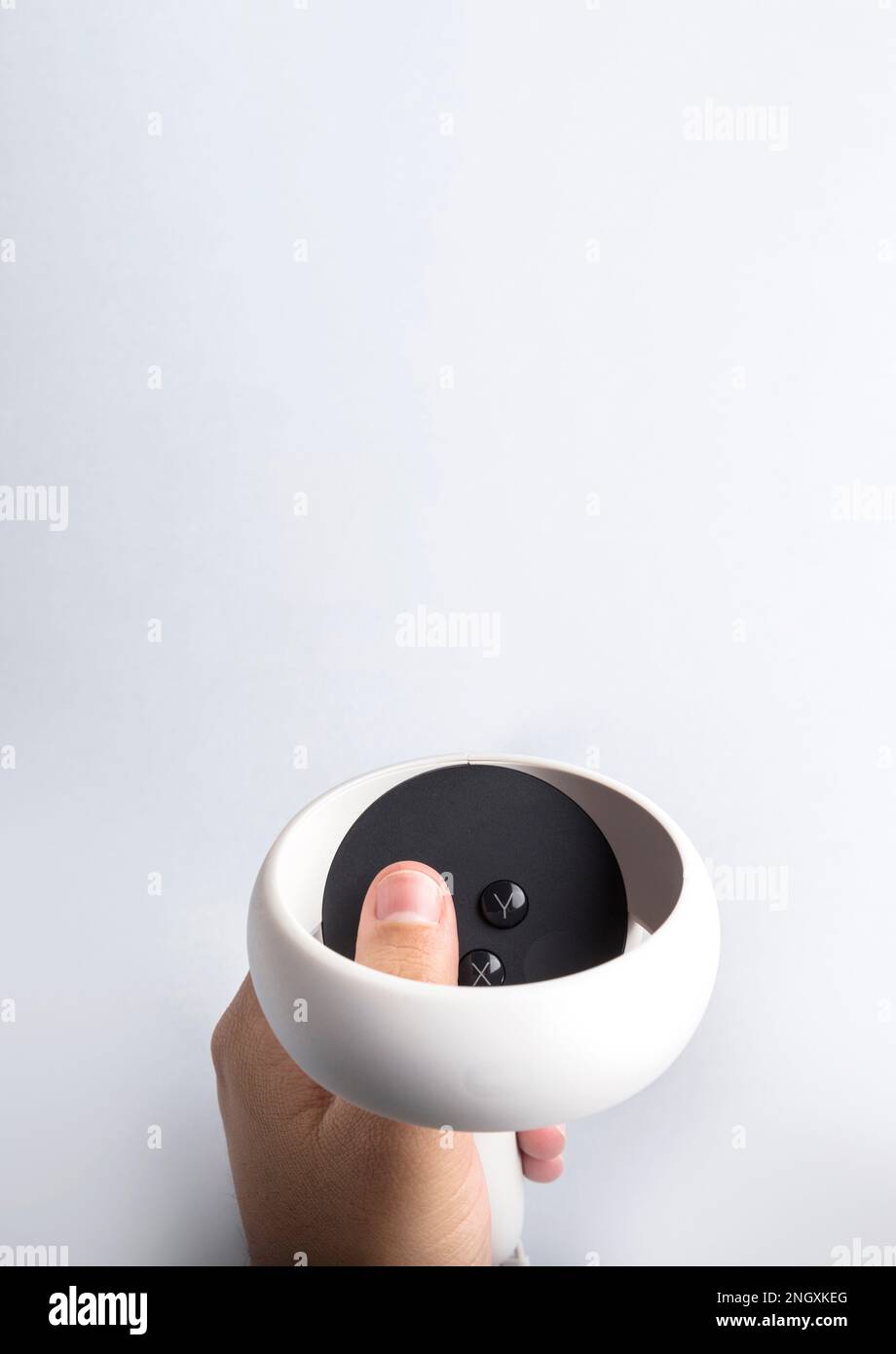 Hand holding virtual reality goggles controller on white background. Space for text. Virtual reality experience Stock Photo